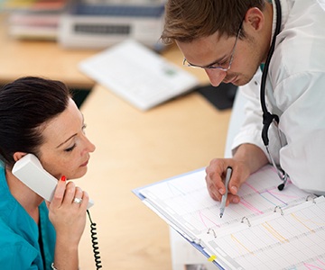 Dentist and assistant looking at calendar