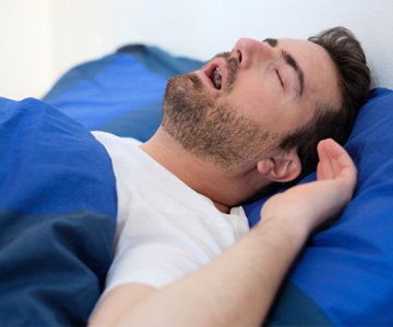 Man with sleep apnea in The Woodlands, TX snoring in bed
