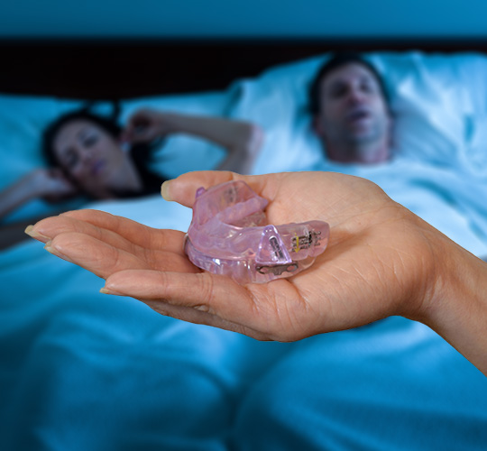 Hand holding an oral sleep appliance