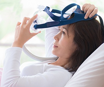 Woman placing CPAP mask