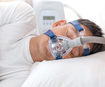 Man sleeping with full CPAP mask