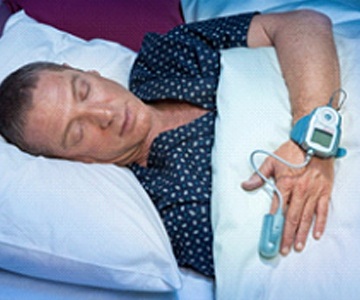 Man sleeping in bed with home sleep test in The Woodlands, TX