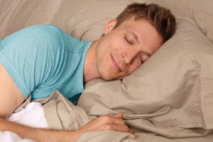 man sleeping peacefully smiling