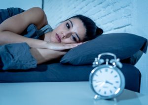 woman lying awake at night who needs a sleep apnea dentist